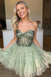 Woman wearing a green sequined homecoming dress indoors