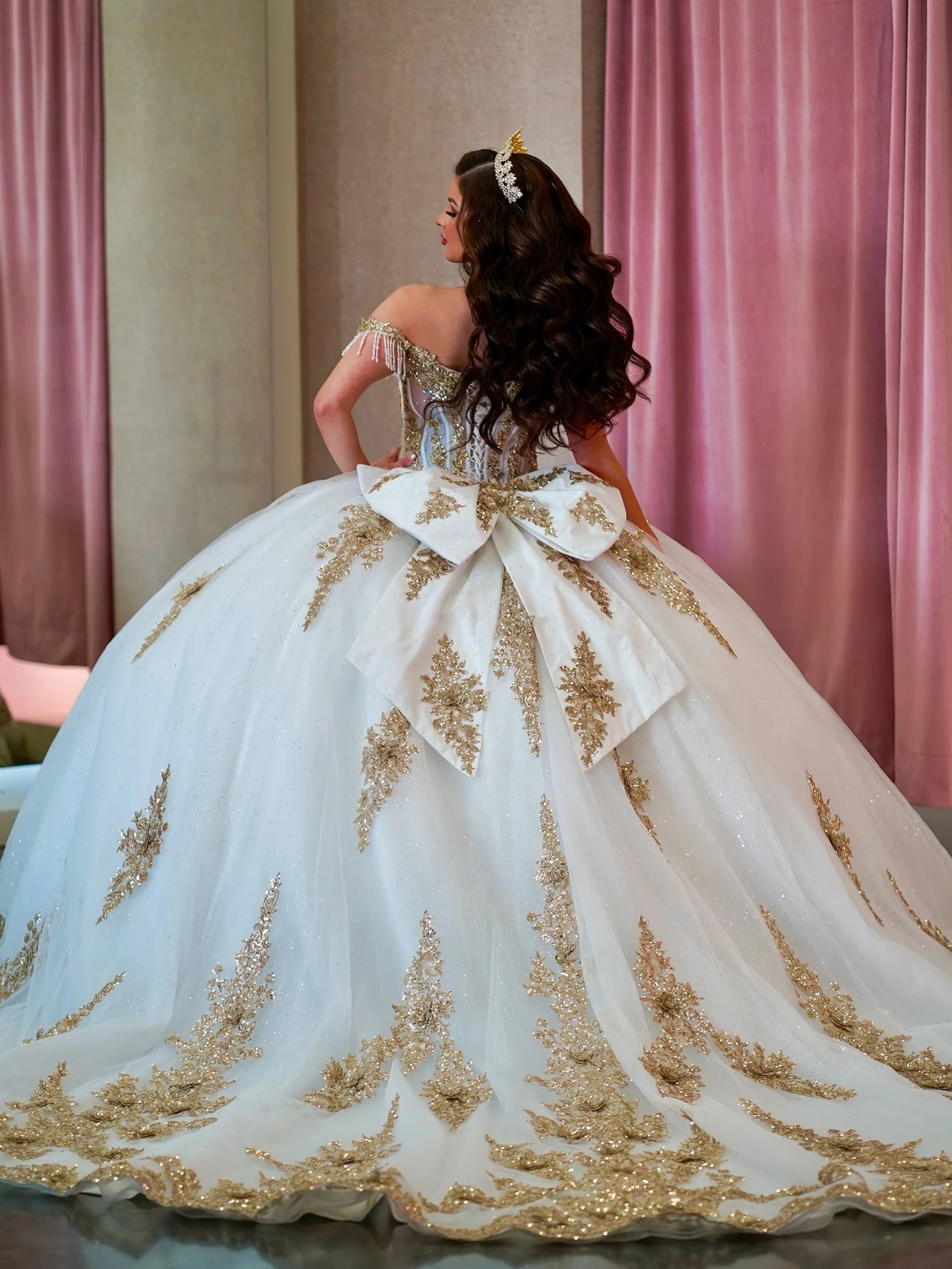 White ball gown quince dress with gold embroidery and a large bow